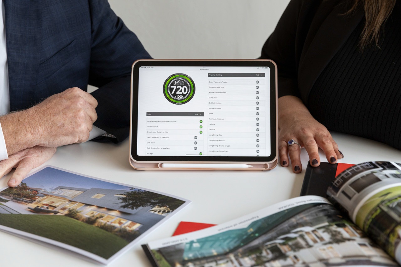 Two advocates reviewing a James Home Rating of 720 out of 1000 on a tablet